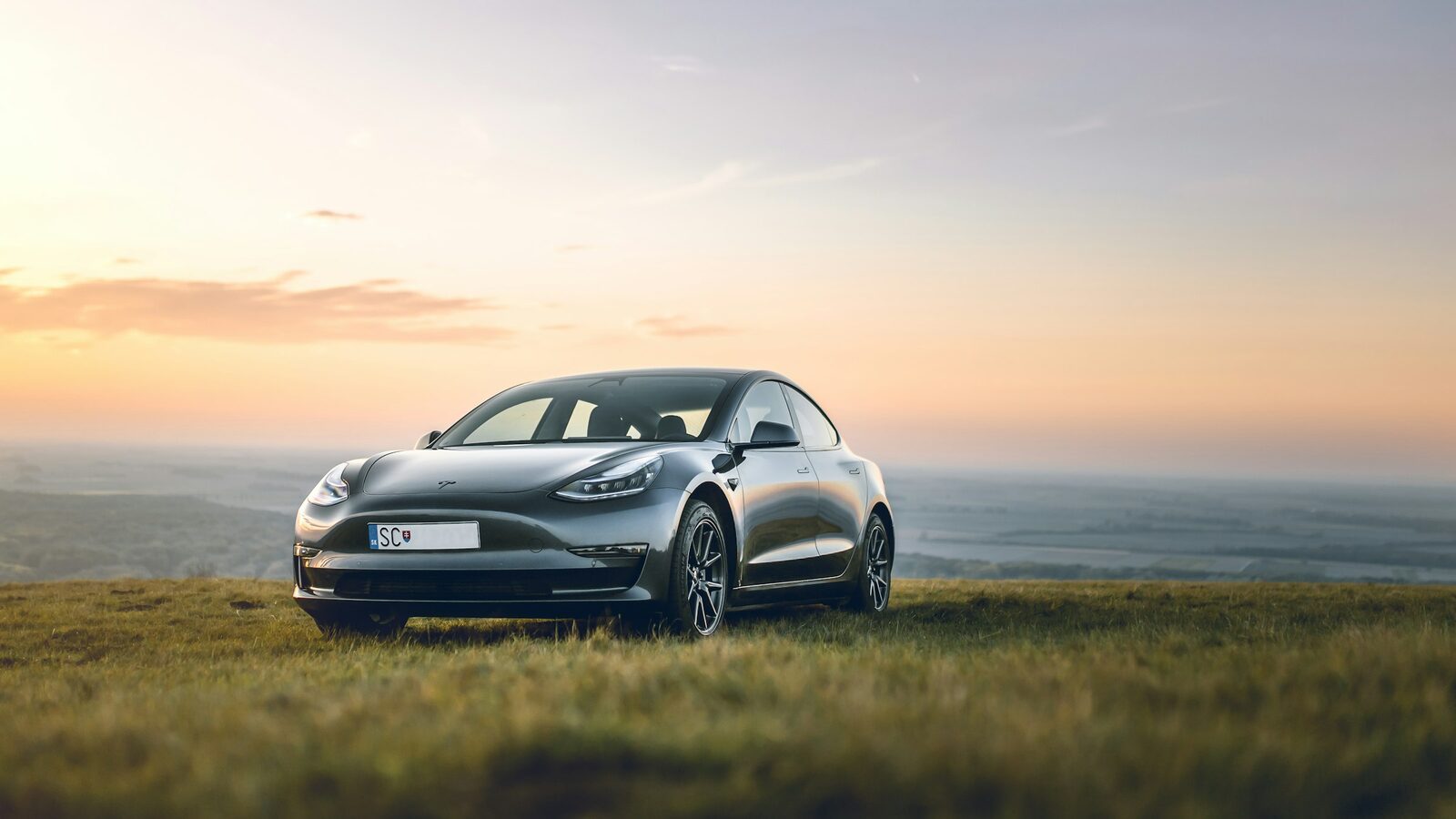 Tesla Model Y on an open road at sunset